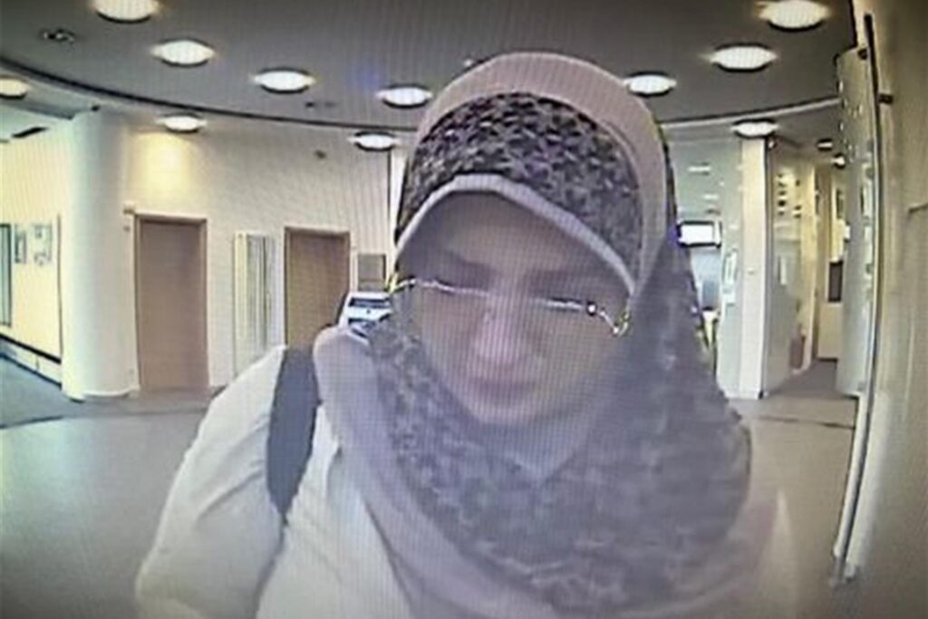 Eine Frau mit Brille, Kopftuch und hellem Mantel Eine Frau mit Brille, Kopftuch und hellem Mantel