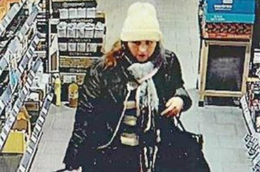 Eine Frau mit weißer Mütze, schwarz-weißem Schal und einer langen schwarzen Jacke Eine Frau mit weißer Mütze, schwarz-weißem Schal und einer langen schwarzen Jacke