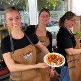 Die Geschwister Kranefoer zeigen einen Currywurst-Teller.