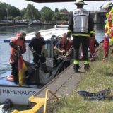Feuerwehrleute stehen am Hafenbecken in Dortmund.