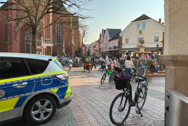 Ein Polizeiwagen auf einem Platz vor einer Kirche.
