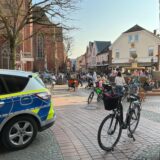 Ein Polizeiwagen auf einem Platz vor einer Kirche.