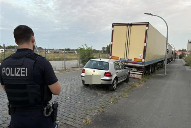 Ein Polizist steht nach der Verfolgungsjagd in Dortmund vor dem abgestellten Fluchtauto.