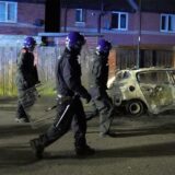 Polizeibeamte gehen an einem ausgebrannten Polizeifahrzeug vorbei, als sie nach einem gewalttätigen Protest in den Straßen von Hartlepool eingesetzt werden. Nach dem tödlichen Messerangriff im britischen Southport kam es auch in der nordostenglischen Stadt Hartlepool zu Zusammenstößen.