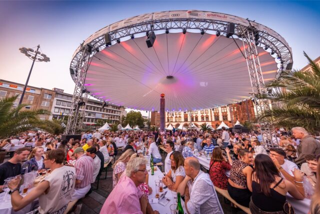 Besucher sitzen bei Gourmedo 2024 in Dortmund an Tischen und genießen die Speisen.