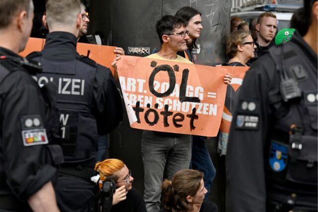Polizisten bewachen Klimaaktivisten der «Letzten Generation» in der Innenstadt, nachdem diese versucht hatten, eine Straße zu blockieren.