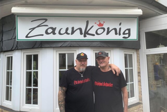 Zwei Mitglieder eines Fußball-Fanclubs stehen Arm in Arm nebeneinander vor dem Zaunkönig in Oer-Erkenschwick.