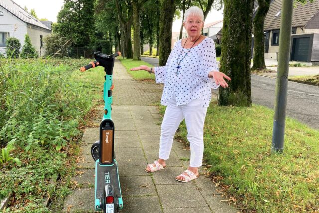 Die Hertenerin Marion Stimpel steht in Herten-Scherlebeck auf einem engen Bürgersteig, auf dem ein E-Scooter abgestellt wurde.