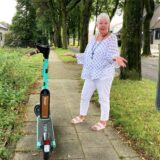 Die Hertenerin Marion Stimpel steht in Herten-Scherlebeck auf einem engen Bürgersteig, auf dem ein E-Scooter abgestellt wurde.