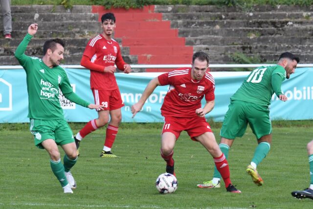 Ein Spieler führt den Ball an seinem Gegenspieler vorbei.