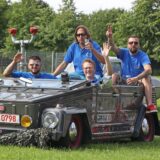 Vier Männer sitzen in einem Kübelwagen von Volkswagen.