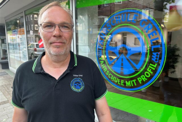 Volker Grell steht vor dem Schaufenster zu seiner Fahrschule.