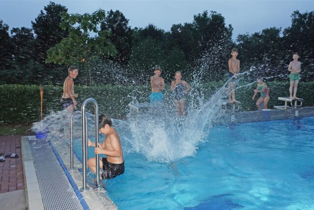Kinder springen vom Block ins Schwimmerbecken