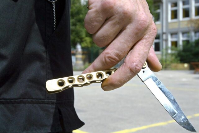 Großaufnahme eines Klappmessers in einer Hand. Die Person, die das Messer hält, ist nicht zu erkennen.