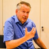 Marc-Oliver Fichter, Geschäftsführer der Wohnungsgesellschaft Recklinghausen, sitzt an einem Tisch und gestikuliert mit der rechten Hand beim Reden.