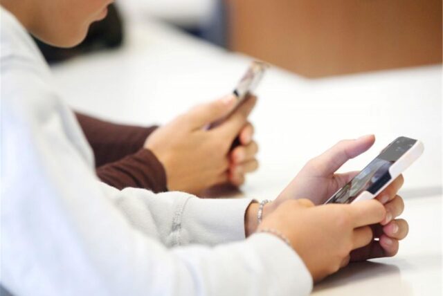 Schülerinnen eines Gymnasiums in Gelsenkirchen benutzen während eines Vortrags über die Anwendungen von Künstlicher Intelligenz (KI) ihr Smartphone im Unterricht.