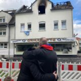 Ein Ehepaar steht vor einem Haus, das durch ein Feuer unbewohnbar geworden ist.