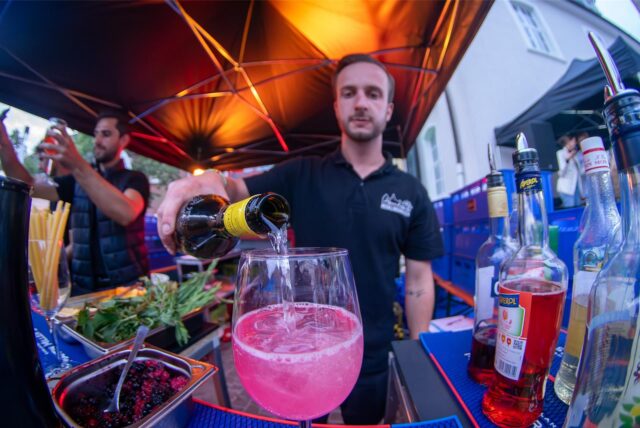 Beim Abendmarkt in Recklinghausen schenkt ein Barkeeper ein Getränk aus.