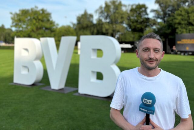 RN-Reporter Philipp Pohl steht neben einem überdimensionalen BVB-Schriftzug im Hoeschpark in Dortmund.