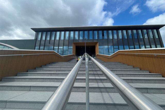 Eine Treppe führt zum Haupteingang eines großen Gebäudes.