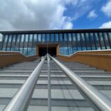 Eine Treppe führt zum Haupteingang eines großen Gebäudes.