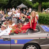 NRW-Kirmeskönigin Pauline I. sitzt beim Festumzug auf der Cranger Kirmes in einem Cabriolet und verteilt Rosen.