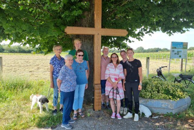 Mehrere Personen stehen an einem Wegekreuz.