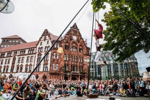 Zuschauer beobachten zwei Akrobaten auf dem MICRO!FESTIVAL.