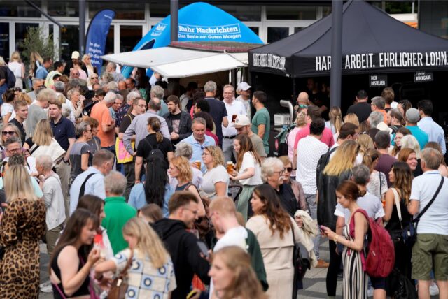 Besucher stehen beim Feierabendmarkt in Dortmund auf dem Theater-Vorplatz.