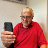 Pfarrer Ludger Ernsting von der Gastkirche in Recklinghausen schaut auf den Bildschirm eines Smartphones.