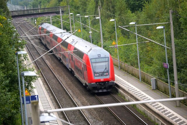 Ein doppelstöckiger Regionalzug der Deutschen Bahn steht an einem Bahngleis.