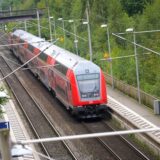 Ein doppelstöckiger Regionalzug der Deutschen Bahn steht an einem Bahngleis.