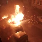 Ein Auto in Dortmund steht in Flammen, ein Feuerwehrmann versucht es zu löschen
