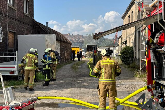 Feuerwehrleute stehen an einem Hinterhof in Recklinghausen-Süd.