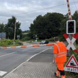 Ein Bahnmitarbeiter hat den Bahnübergang an der Paschenbergstraße in Herten mit einem dicken Seil  anstelle der Schranken abgesperrt, weil in Kürze ein Zug kommen soll.