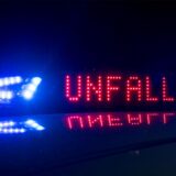 Blaulicht und rotes LED-Display „Unfall“ auf dem Dach eines Polizeiwagens.