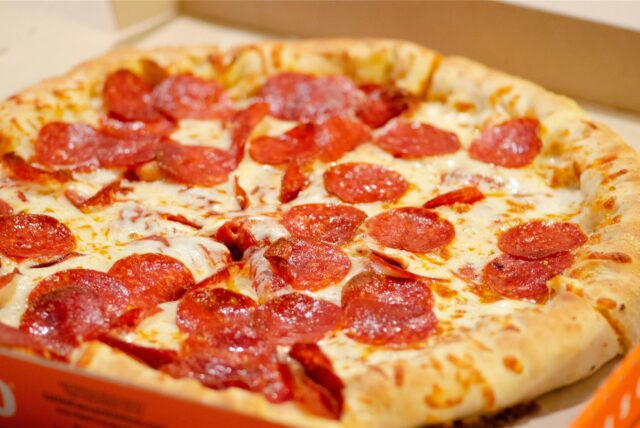 Salami-Pizza in einem Pizzakarton.