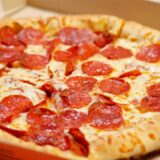 Salami-Pizza in einem Pizzakarton.