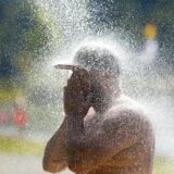 Ein Mann kühlt sich mit Wasser ab.