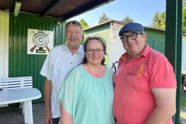 Geschäftsführer Werner Rommeswinkel, Schützenkönigin Anja Gibson und Vorsitzender Raymund Ridderskamp stehen vor dem Vereinsheim des Hervester Bürgerschützenvereins.