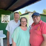 Geschäftsführer Werner Rommeswinkel, Schützenkönigin Anja Gibson und Vorsitzender Raymund Ridderskamp stehen vor dem Vereinsheim des Hervester Bürgerschützenvereins.