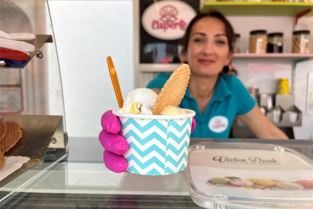 Eine Mitarbeiterin der Eisperle in Dortmund hält einen Eis-Becher ins Bild.