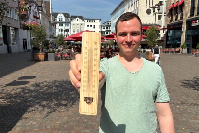 Benedikt Iwen steht mit einem Thermometer auf dem Altstadtmarkt in Recklinghausen.