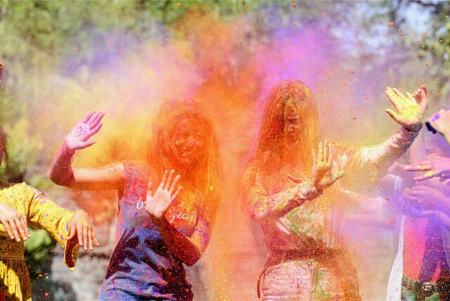 Zwei Frauen werden beim Lathmar Holi Festivalsmit Farbpulver beworfen.