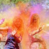 Zwei Frauen werden beim Lathmar Holi Festivalsmit Farbpulver beworfen.