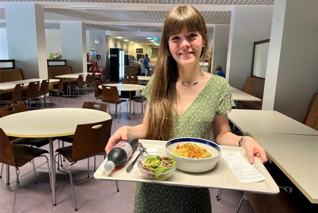 Redakteurin Janka Hardenacke steht in der Cafeteria des Prosper-Hospitals mit einem gefüllten Tablett.