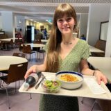 Redakteurin Janka Hardenacke steht in der Cafeteria des Prosper-Hospitals mit einem gefüllten Tablett.