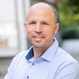 Ein Mann schaut lächelnd in die Kamera