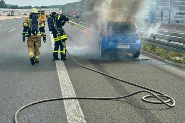 Feuerwehrleute löschen ein brennendes Auto auf der A43 bei Recklinghausen.