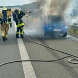 Feuerwehrleute löschen ein brennendes Auto auf der A43 bei Recklinghausen.